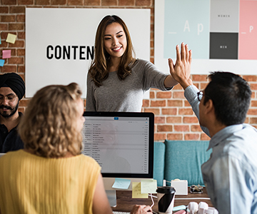 Office setting, people giving each other high five